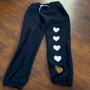 Black sweatpants with white and gold heart